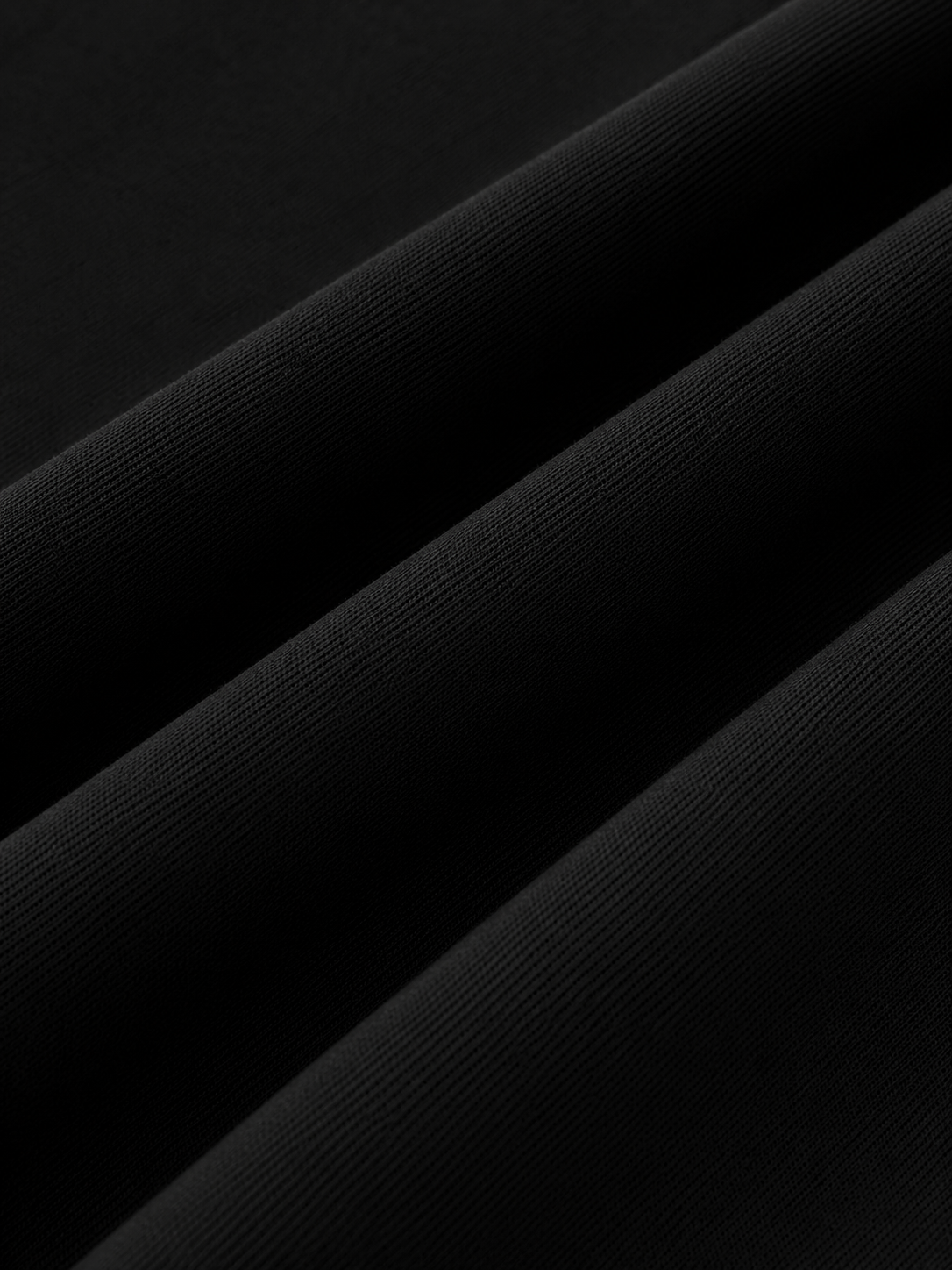 Close-up of the Steelvora black oversized crewneck sweatshirt fabric, showcasing the premium cotton-blend texture, smooth finish, and soft drape.