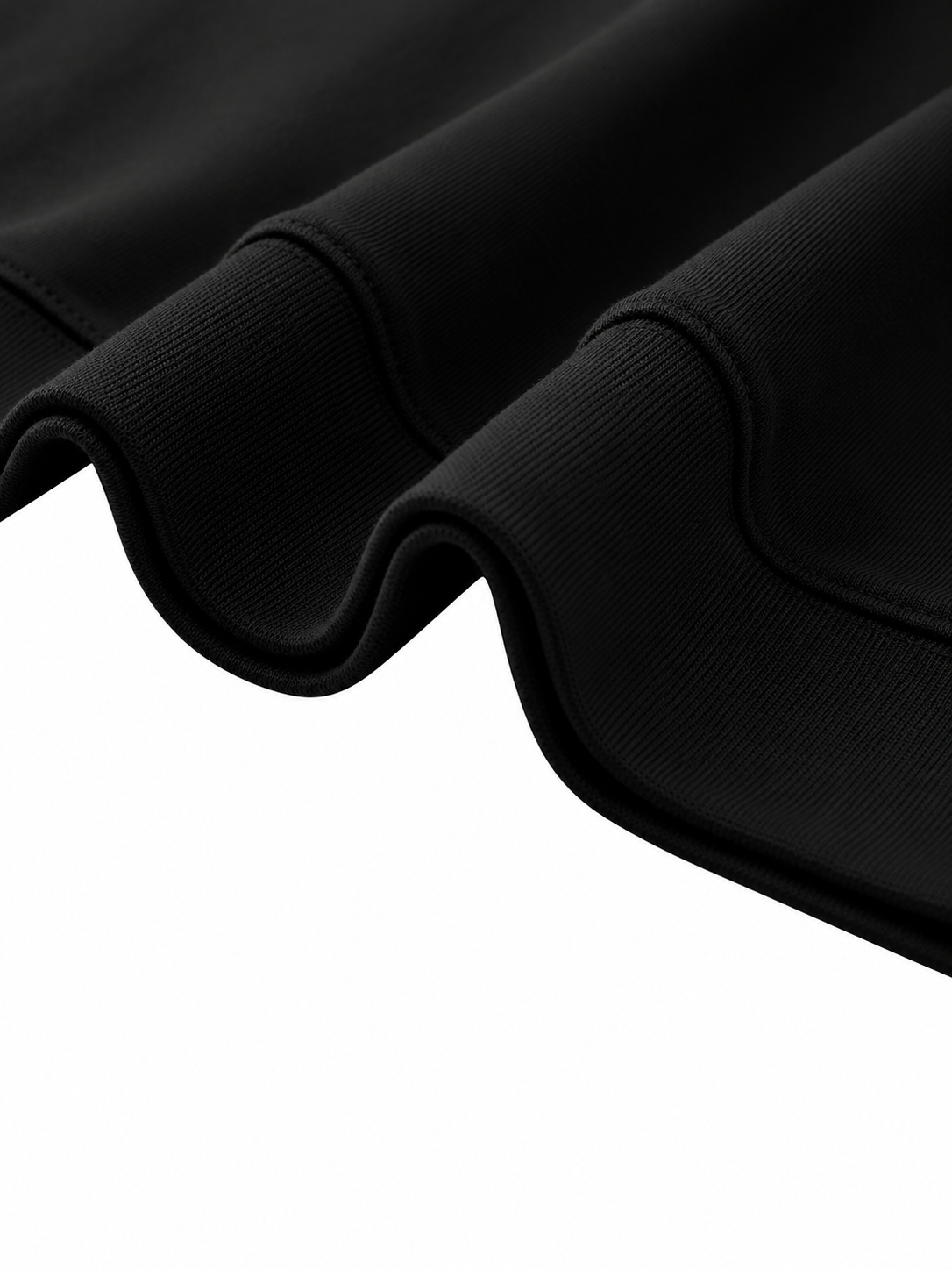 Close-up of the ribbed hem on the Steelvora black oversized crewneck sweatshirt, showing premium cotton-blend fabric and construction details.